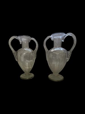 two vases that are sitting side by side on a black background