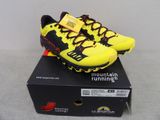 La chaussure de course jaune et noire est posée sur une boîte.