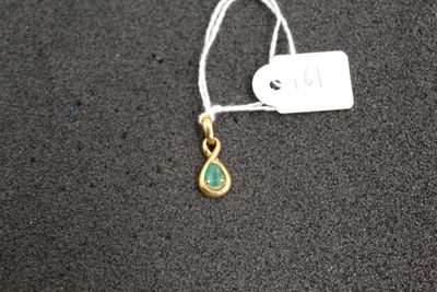 a close up of a gold and green necklace with a tag on it