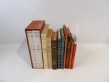 several books are stacked on top of each other on a white surface