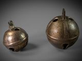 pair of bronze bells on a gray background
