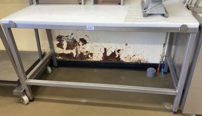 une table blanche sur laquelle se trouve un ordinateur portable, dans une pièce
