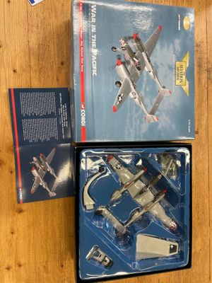 two boxed boxes with a model of a fighter plane on a wooden surface