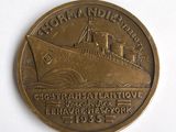 une pièce de bronze sur laquelle figure un bateau