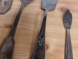five spoons and two spoons sitting on a table