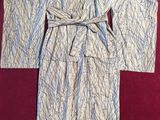 a white and blue robe with a tie on a red surface