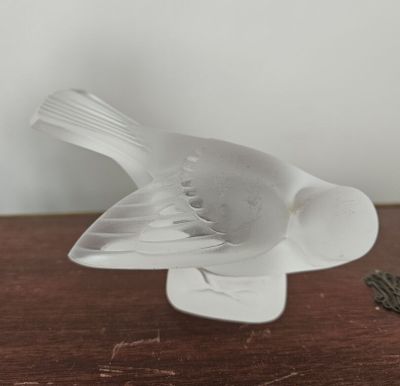 un oiseau blanc posé sur une table en bois