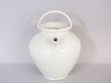 a white vase with a handle on a table