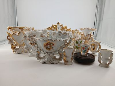 a white and gold vase and other decorative items on a white surface