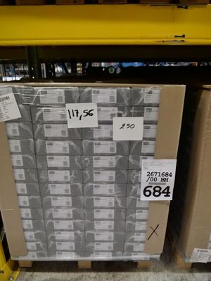 une grande pile de cartons posée sur une palette dans un magasin