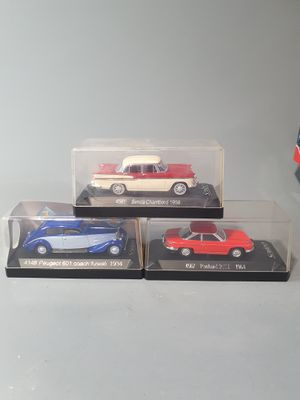 three toy cars in a display case on a table