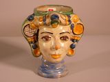 a ceramic head of a woman with a tennis racket on her head
