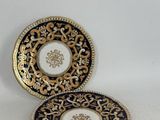 deux assiettes ornées de motifs dorés et bleus, posées sur une surface blanche