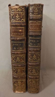 deux vieux livres posés l'un sur l'autre sur une table