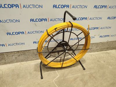 a yellow hose on a black stand in front of a wall