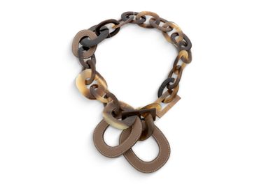 Le collier est en cuir marron et noir, avec un fermoir en métal.