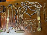 a wooden table with a bunch of jewelry on it