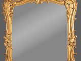 un miroir au cadre doré richement décoré, orné d'oiseaux et de fleurs