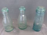 three glass bottles that are sitting on a table
