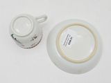 a small cup and saucer sitting on a table