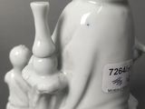 a white figurine of a person holding a vase