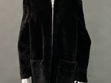 an image of a mannequin wearing a black coat and hat