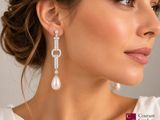 a woman wearing a white dress and pearl earrings