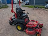 a red lawn mower sitting on top of a dirt field