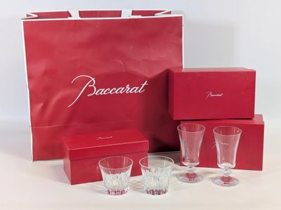 une boîte rouge contenant quatre verres et un sac rouge sur lequel est inscrit le mot « Baccarat »
