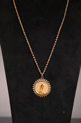 a necklace with a gold coin on a black mannequin