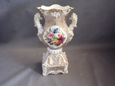 a white vase with flowers painted on it on a stand