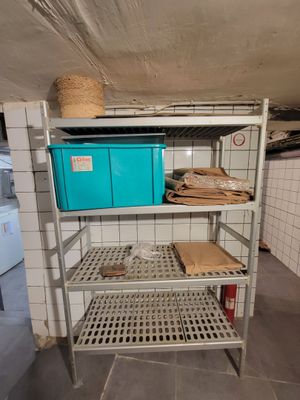 une étagère sur laquelle se trouvent quelques cartons, dans une pièce