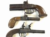 trois vieilles armes à feu sont exposées sur un fond blanc