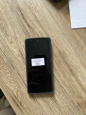 un téléphone portable posé sur une table en bois, à côté d'une tasse de café