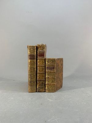 deux vieux livres posés l'un sur l'autre sur une surface blanche