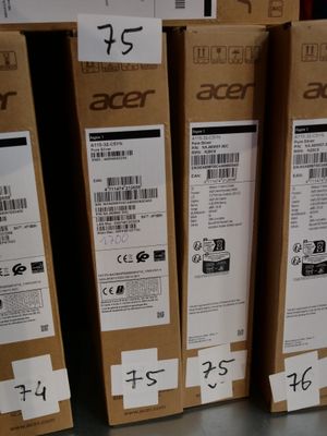 Des cartons contenant des produits Acer sont empilés sur une étagère dans un magasin