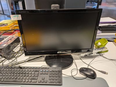 une photo d'un bureau d'ordinateur avec un écran et un clavier