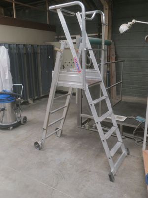 a ladder that is sitting in a room next to a chair