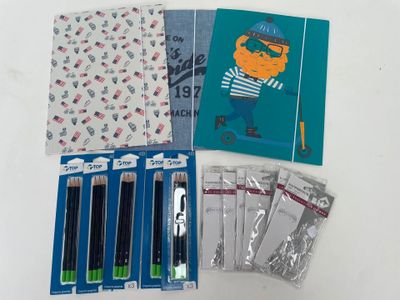 beaucoup de stylos et de cahiers posés sur la table