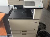 une imprimante posée sur un bureau, à côté d'une poubelle