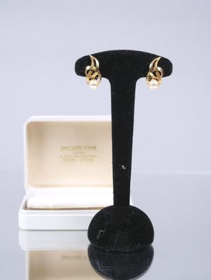 an image of a pair of earrings on a stand with a box in the background