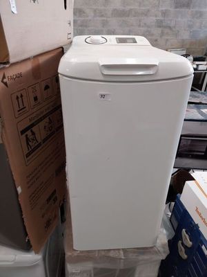 un réfrigérateur blanc posé sur une pile de cartons