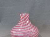 un vase rayé rouge et blanc posé sur une table