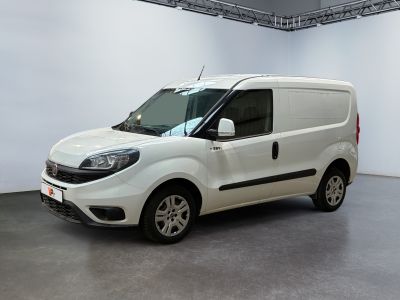 the small white van is parked in a large room