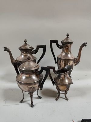 deux théières en argent et une cafetière posées sur une table