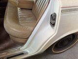 a white car with a tan leather seat in the back of it