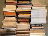 many books stacked on top of each other on the floor