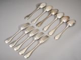 six silverplated spoons and six forks on a white surface