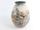 a vase with a painting on it sitting on a table