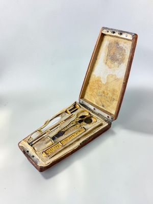 an old wooden case with a pair of scissors and a pair of scissors in it